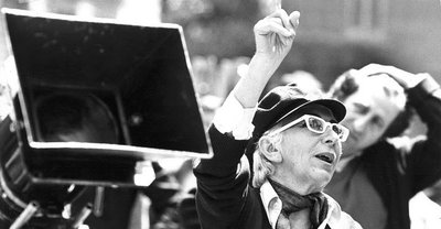 A black and white photograph of Lina Wertmüller in front of a group of people.