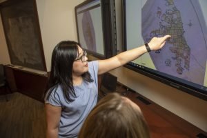 Graduate fellow Cristina Sakamoto points at a map on screen