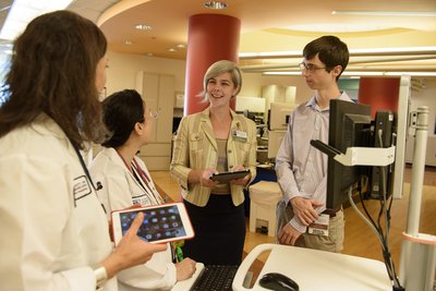 Debra Werner talks to doctors and a medical student at the hospital
