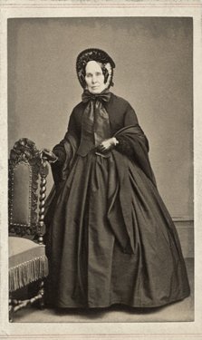 Full-body portrait of a woman in Victorian dress.