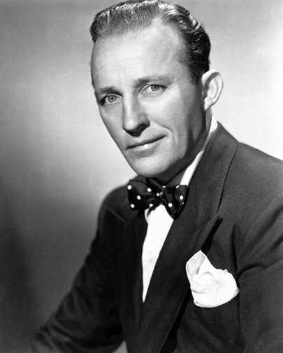 A black and white portrait of Bing Crosby wearing a suit and polka-dotted bowtie