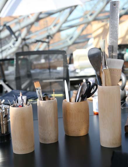 Jars with paint brushes, scissors, and other equipment.
