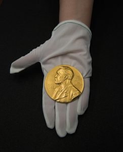 Nobel Prize medal in a gloved hand
