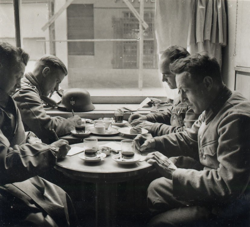 A group of men writing in a cafe.