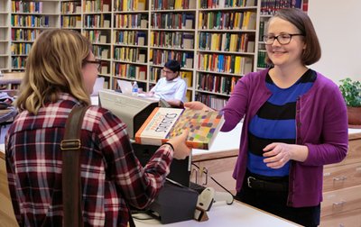 Handing a student a book at Eckhart Library