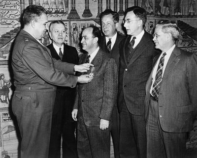 Major General Leslie R. Grooves pins a Medal of Merit on physicist Enrico Fermi