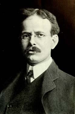 Headshot of a man with glasses and a mustache.