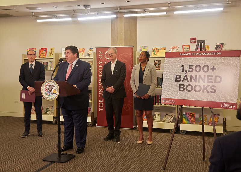Gov. Pritzker at podium with other speakers and 1,500+ BANNED BOOKS sign