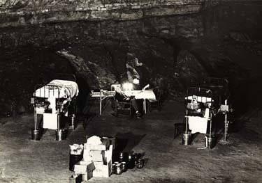 Several pieces of furniture, including a bed, inside a dark cave.