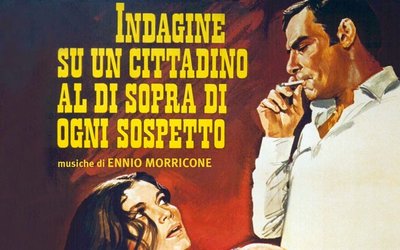 A movie poster with yellow text on a red background. A man is standing and smoking, and a woman' head is barely visible on the bottom of the frame.