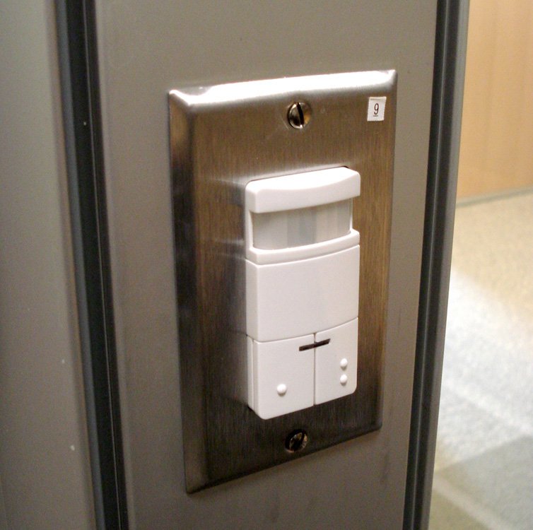 A small white sensor mounted on a wall.