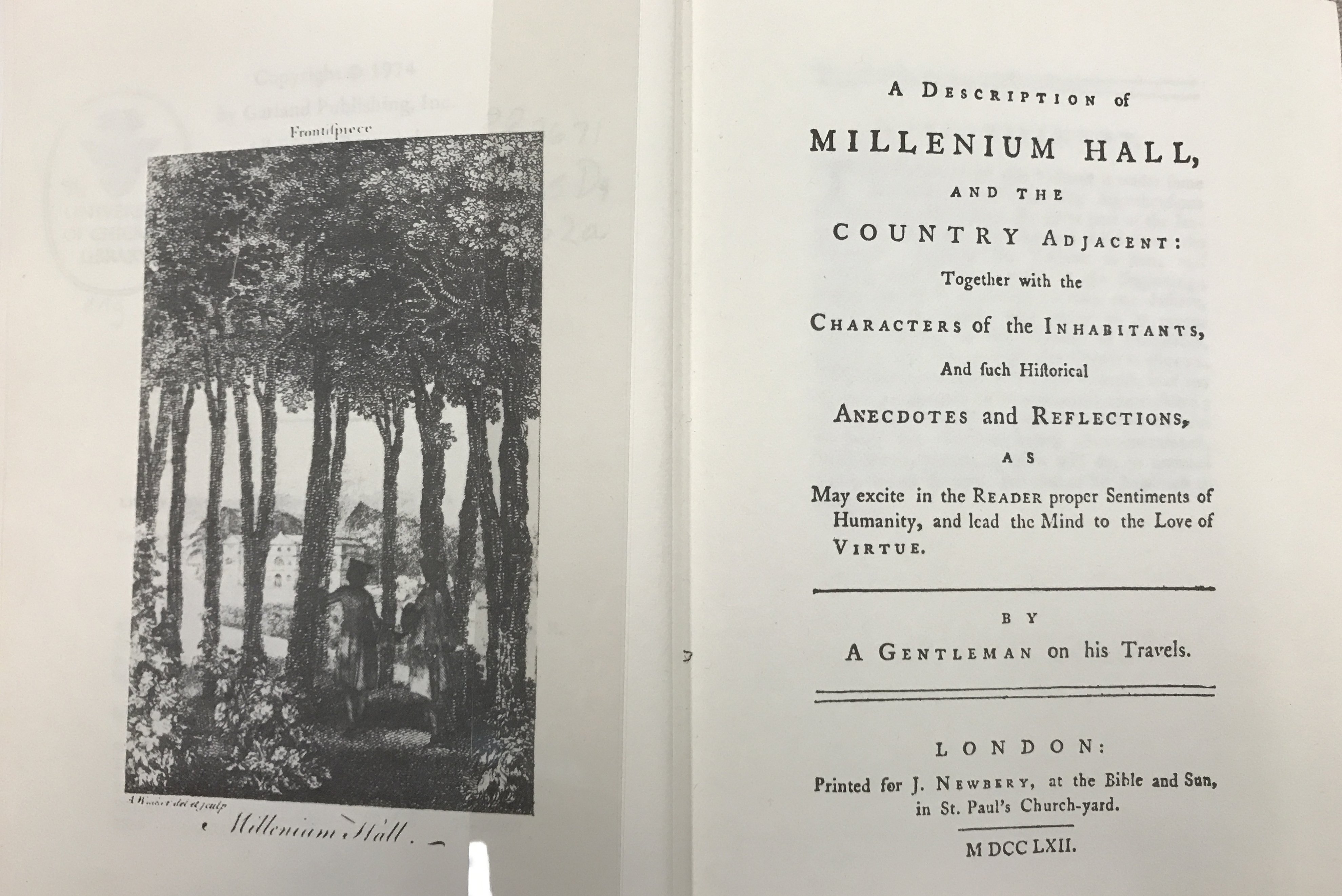 Open book with cover page and engraving of outdoor scene