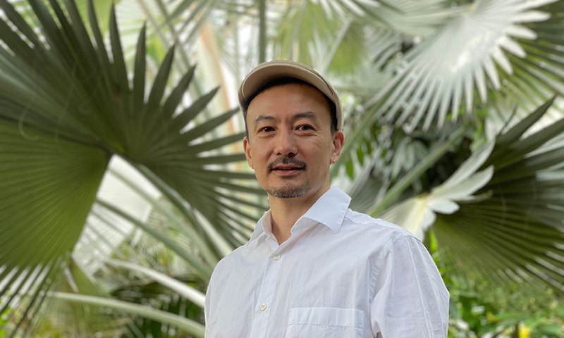 Kikù Hibino in front of green leaves