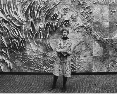 Black and white photo of Duckworth in front of ceramic mural