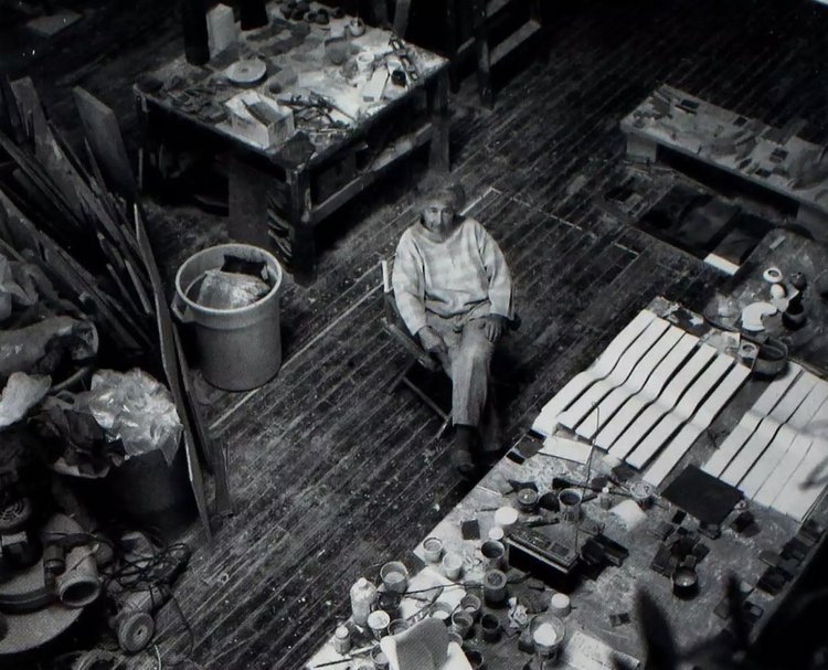Duckworth sitting on a chair surrounded by tables with art supplies on them