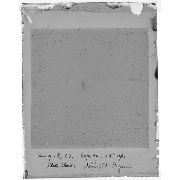 A glass plate negative of Ry60. The background of the plate is gray, and the emulsion is peeling around all of the plate edges. Handwritten at the top of the plate is "Ry60 H.I 53 Pegasi." Handwritten at the bottom is Aug, 19, 03. Exp. 3h. 18" ap./Plate show. (Mess. ^ H.I) 53 Pegasi." The center of the plates is a slightly darker gray, with black stars throughout the field. Just left of center is M53, which is a small, fuzzy, vertical mark.