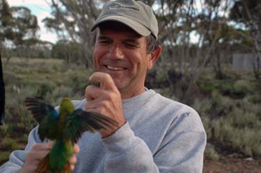 A man allows a hummingbird to alight on his hand.