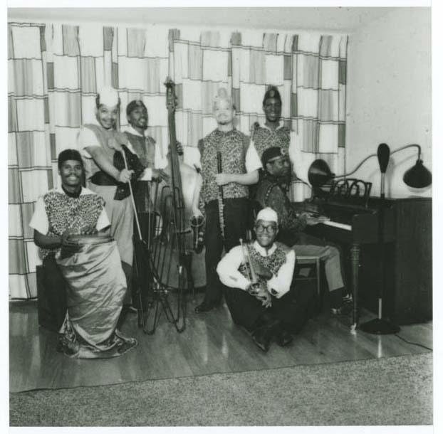 A group of musicians with various instruments including a bass, a piano, and a trumpet.