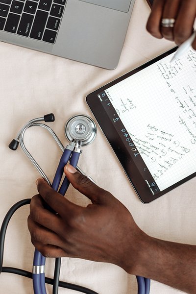 Hands holding a digital tablet and a stethoscope