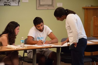 Elizabeth Foster (right) talks to two students, reviewing handouts