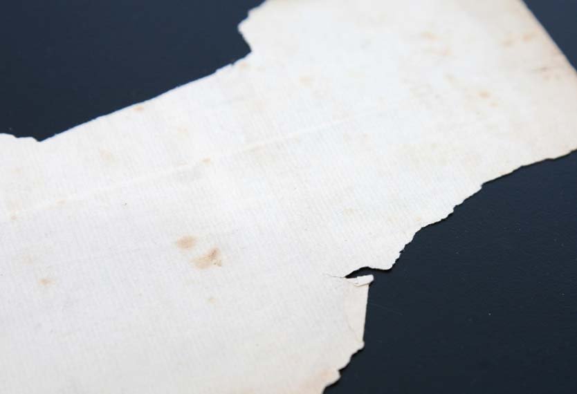 A slightly cracked and discolored sheet of white paper.