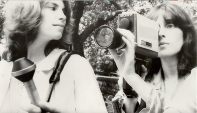 Two women with a video camera and microphone
