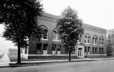 A stately building with trees in front.