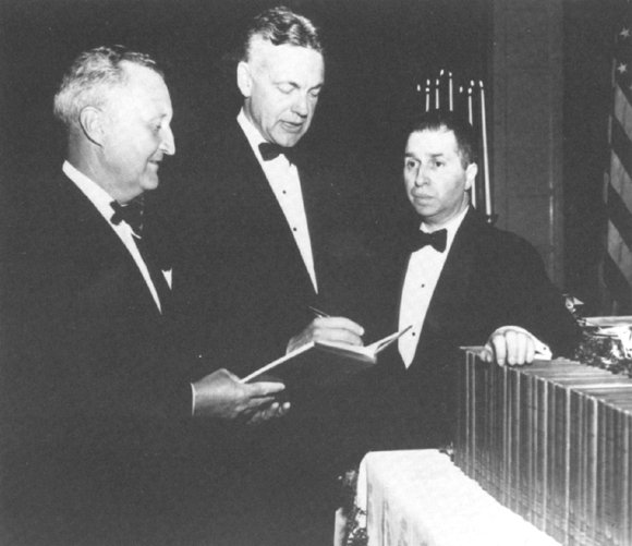 William Benton, Robert M. Hutchins, and Mortimer Adler with a presentation copy of Great Books of the Western World for Queen Elizabeth II, April 15, 1962