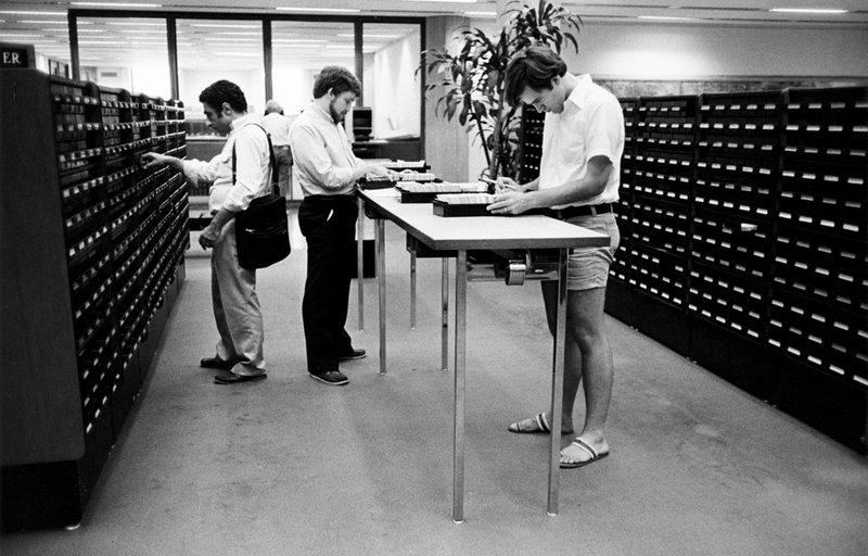 Three students using the card catalog