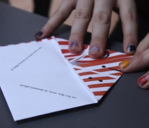 Hands fold a fortune teller with text inside