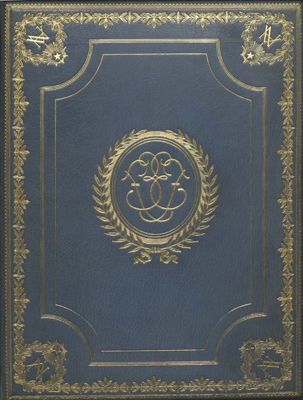 A photo of the navy blue cover of Enrico Fermi's Nobel Prize, with a wreath in gold in the center and detailed gold border