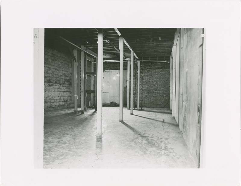 A black and white photo of a plain brick room