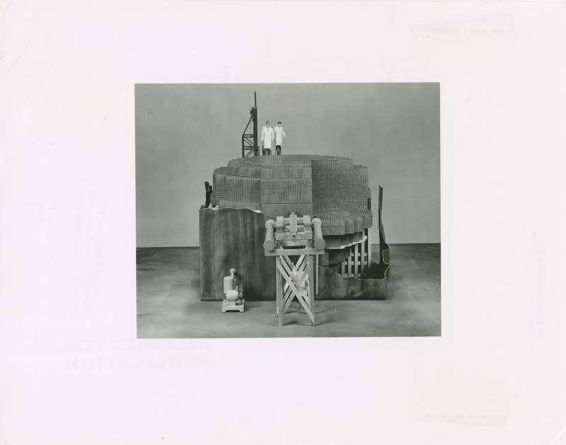 A black and white photo of a scale model of CP-1 from the front, including miniature scientists