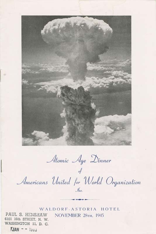 The front cover of a dinner program, which features a black and white photo of the mushroom cloud as a result of the bomb.