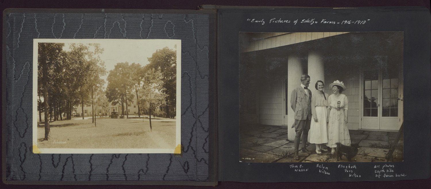 Black-and-white snapshots pasted onto black photograph album pages. Handwritten notes in white ink indicate that the view of the Edellyn Farm house is from the south side. Depicts a white colonial mansion with an expansive lawn and trees. The family photograph shows Thomas E. Wilson, Helen Wilson, and Elizabeth Foss Wilson standing close together on the back porch/patio. They are laughing together.